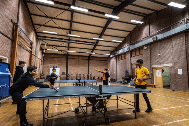 Boys playing table tennis indoors