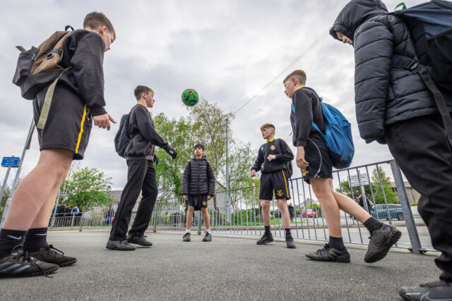 Pupils playing with a football in the school yard