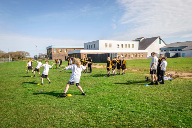 Pupils throwing javelins on the school fields